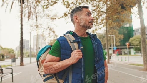 Preview: Mature man tourist wearing casual clothes, with backpack on his shoulder