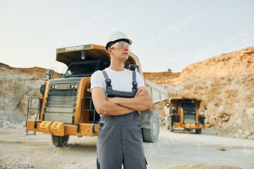 Preview: In grey colored uniform. Worker in professional uniform is on the borrow pit at daytime