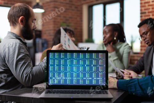 Preview: Laptop computer with annual report on screen standing on table