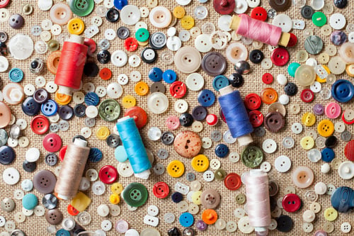 Preview: sewing buttons and spools of threads background