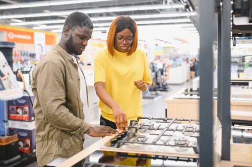 Preview: Young african american man and woman buying new gas stove in appliances shop