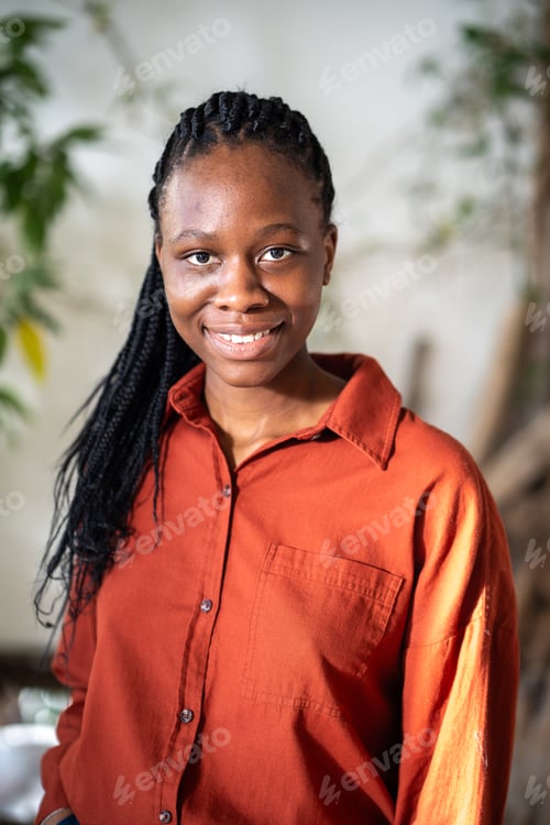 Preview: Portrait of pleased african american girl with braids smiling looking at camera with confident gaze.