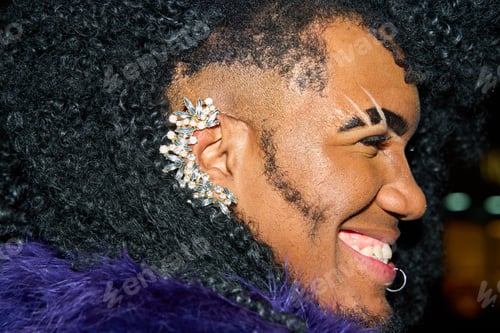 Preview: Smiling drag queen wearing rhinestone ear cuff and purple fur boa