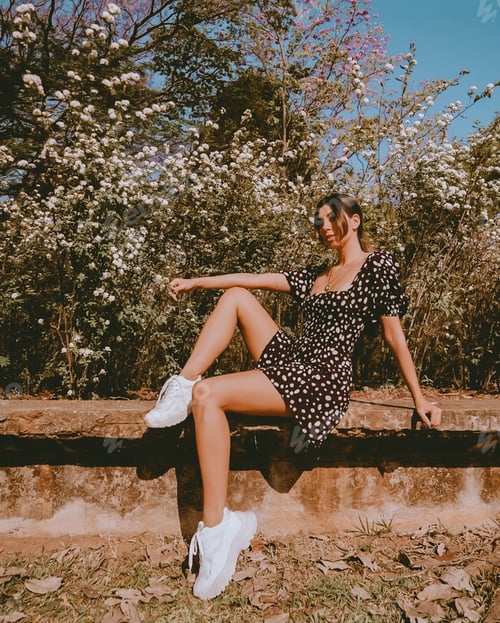 Preview: Young Woman Sitting Among Lush Greenery and Blooms