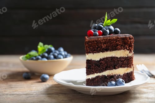 Preview: Plate with slice of chocolate sponge berry cake on wooden table