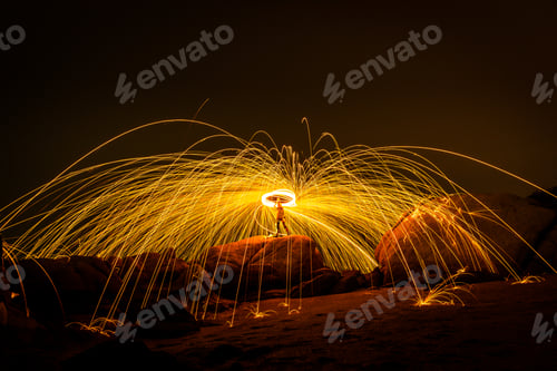 Preview: Fire dancing show swing lighting effects circle on bridge dark sky on night time.