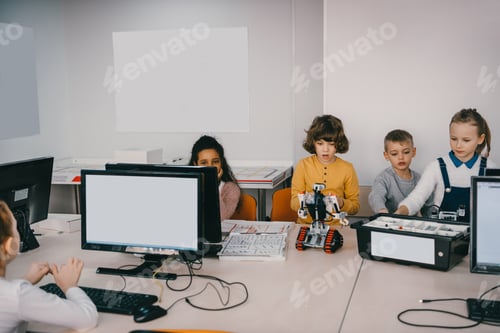 Preview: focused teen kids programming diy robot at machinery class