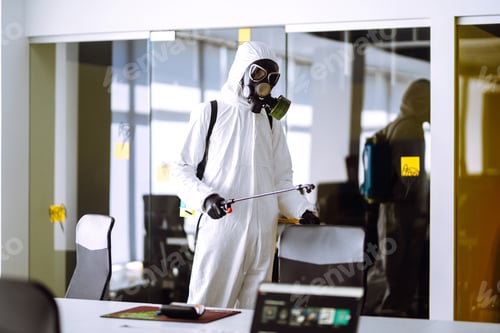 Preview: Disinfecting of office to prevent COVID-19, Man in protective hazmat suit with spray chemicals.