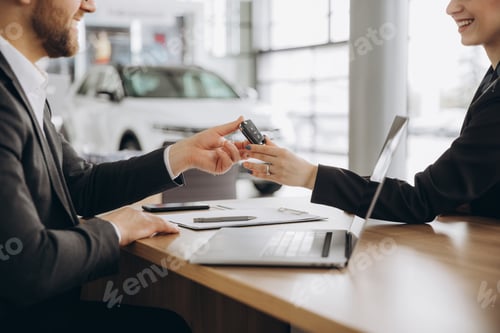Preview: Close-up of a manager handing the car keys to a new owner to a woman at a table with a laptop