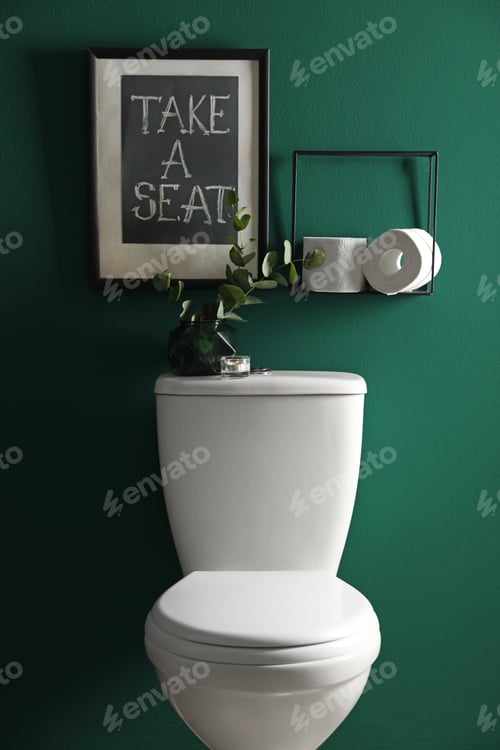 Preview: Decor elements, paper rolls and toilet bowl near green wall. Bathroom interior