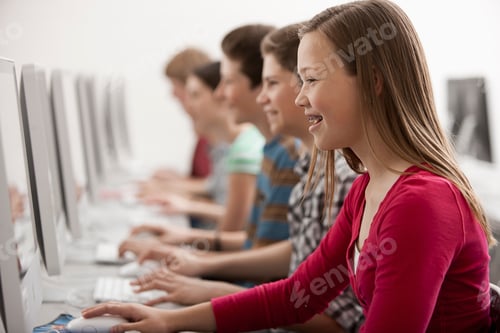 Preview: A group of young people, boys and girls, working at computer screens in class.