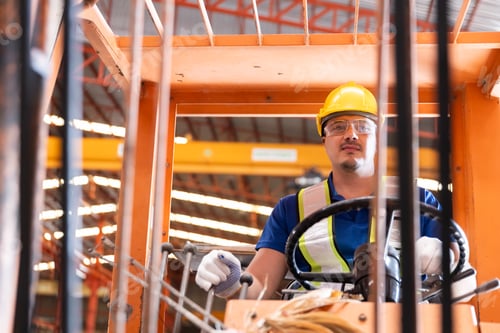 Preview: Worker wearing safety uniform drive forklift move product iron metal on shelves in warehouse.