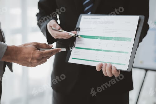 Preview: Two businessmen pointed to the material for the meeting, working together to plan to develop and sol