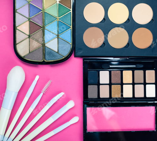 Preview: Beauty products on a pink background in a makeup setup during daytime