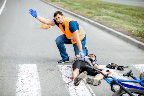 Preview: Road accident with injured cyclist and man providing first aid