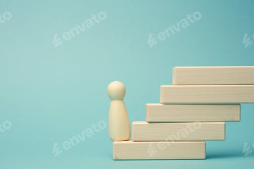 Preview: Wooden figurine of a man stands on a staircase made of blocks on the first step
