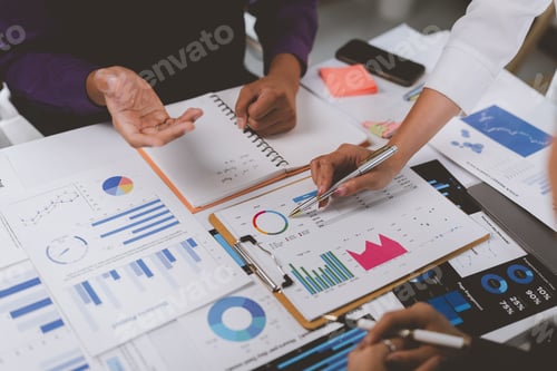 Preview: Business people analyzing financial charts and graphs at meeting