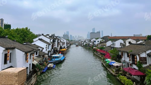 Preview: houses and boats in a canal with the city in the distance