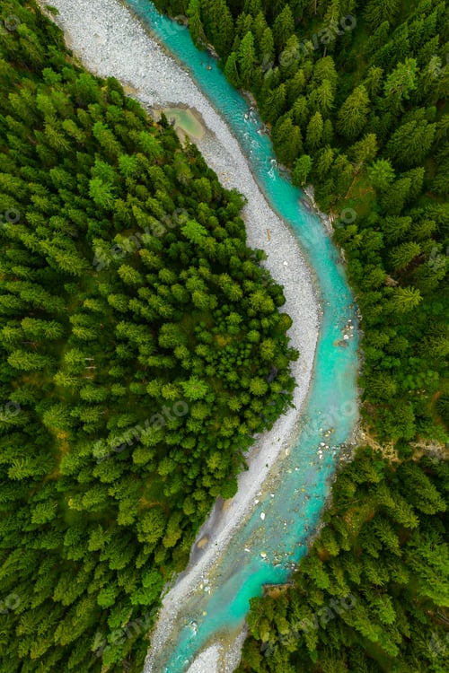 Preview: Inn River flowing in the forest in Switzerland. Aerial view from drone on a blue river in the