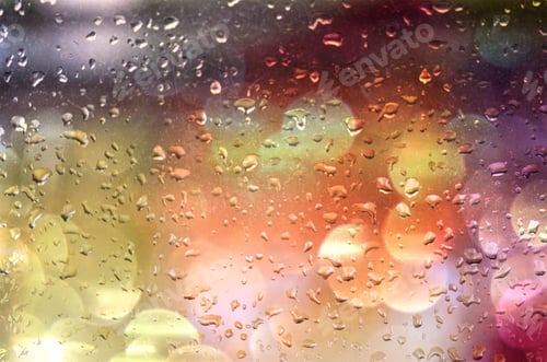 Preview: Rainy day weather, rain drops on a window with bokeh of multicolored lights