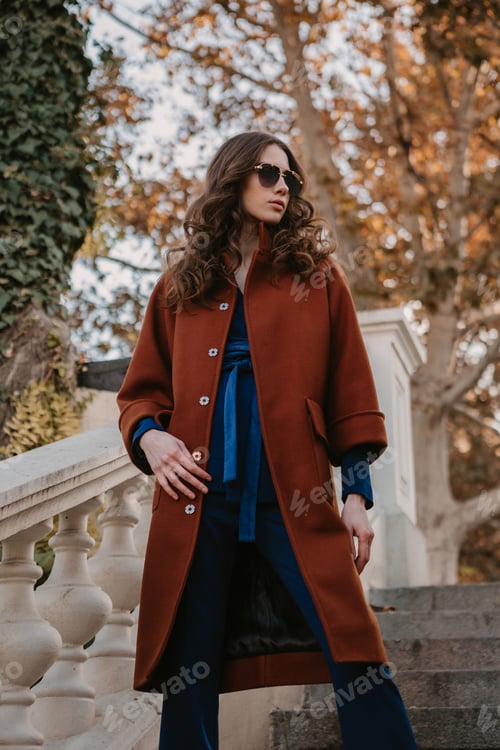 Preview: beautiful stylish woman walking in street stairs dressed in warm brown coat and blue suit