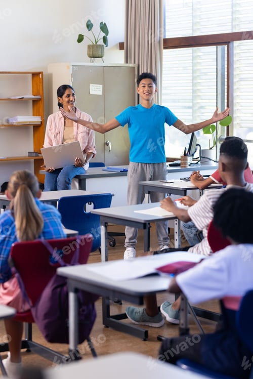 Preview: Presenting in classroom, boy engaging indian female teacher and students watching in school