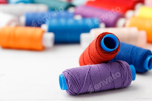 Preview: Colorful sewing accessories on white wooden table