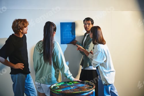 Preview: african american man finding clue near interracial friends during quest in escape room, mystery