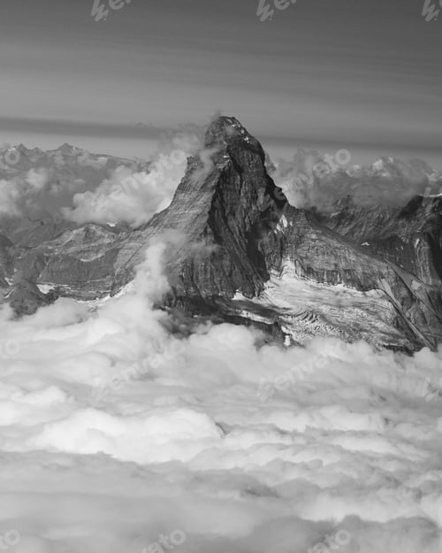Preview: Iconic Matterhorn peak towers above a sea of clouds, captured in stunning black and white.