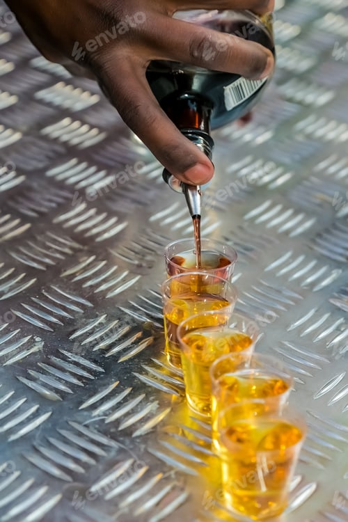 Preview: Vertical shot of a barman pouring a round of shots