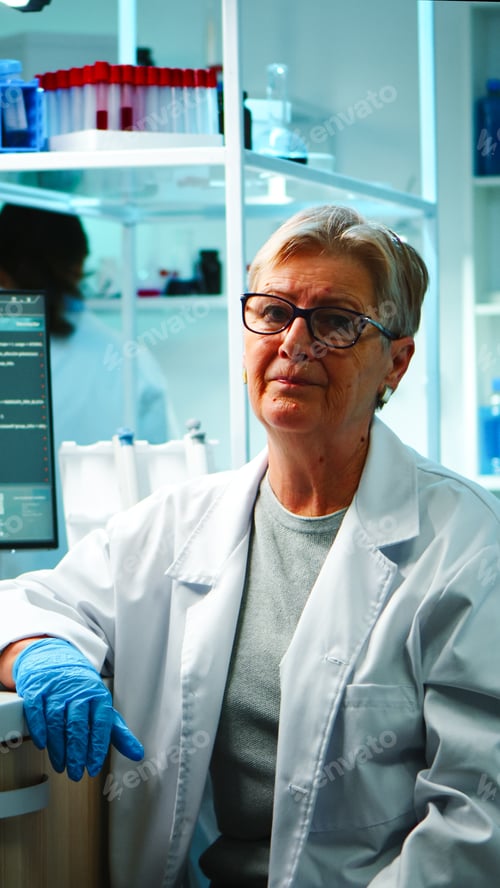Preview: Portrait of old chemist woman with fatigued face in front of camera