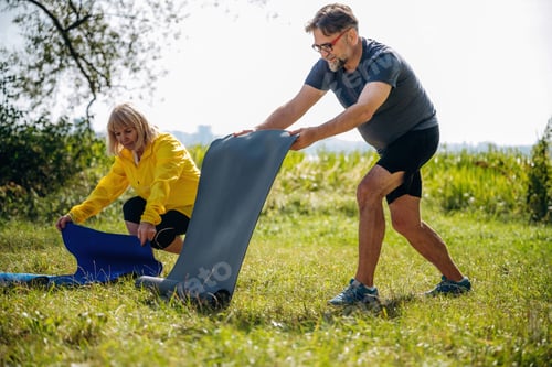 Preview: With yoga mats. Senior couple together outdoors at nature