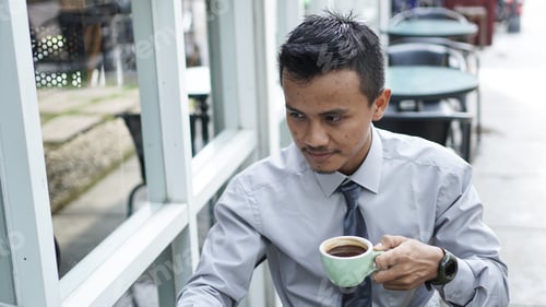 Preview: Thoughtful Man Enjoying Coffee Outdoors at Cafe