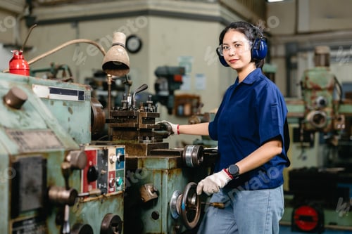Preview: Portrait happy engineer worker with safety eyes protection professional working with metal lathe