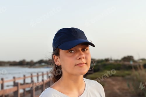 Preview: Teenager standing by the sea and wearing t-shirt and baseball cap