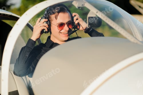 Preview: Portrait of confident young man pilot in small plane