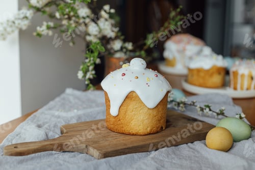 Preview: Homemade easter bread, natural dyed eggs and spring blossom on rustic table in room. Happy Easter