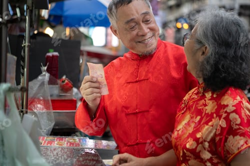 Preview: A happy senior couple strolls along a Chinatown in Bangkok, Thailand,