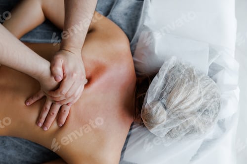 Preview: Therapist performing deep tissue back massage on woman