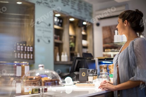 Preview: Young woman waiting at cafe counter