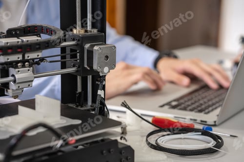 Preview: Student setting up 3D printer,using laptop, close up