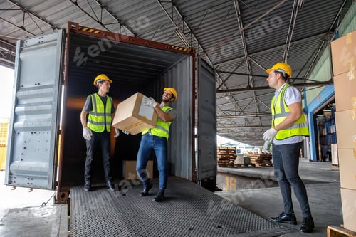 Preview: Worker carry carton box taken from 40 feet steel container on the trailer truck park at warehouse