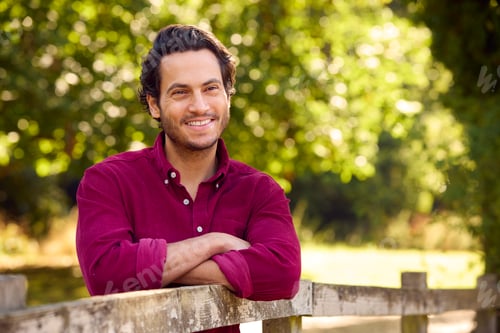 Preview: Portrait Of Smiling Casually Dressed Mature Man Leaning On Fence On Walk In Countryside