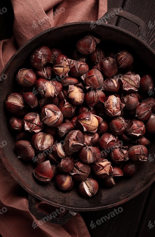 Preview: Roasted chestnuts, in an iron pan, wooden table, top view, no people, rustic style,