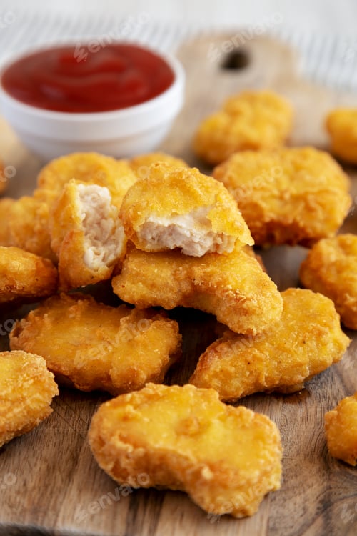Preview: Crunchy Chicken Nuggets with Ketchup on a wooden board, side view. Close-up.