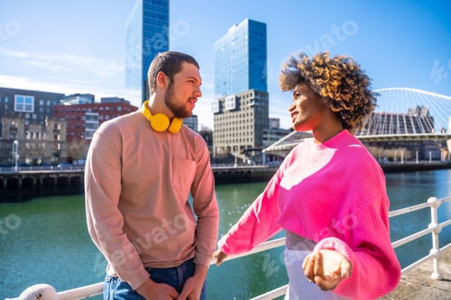 Preview: Cheerful young couple in vibrant outfits enjoying some quality time together outdoors in urban area