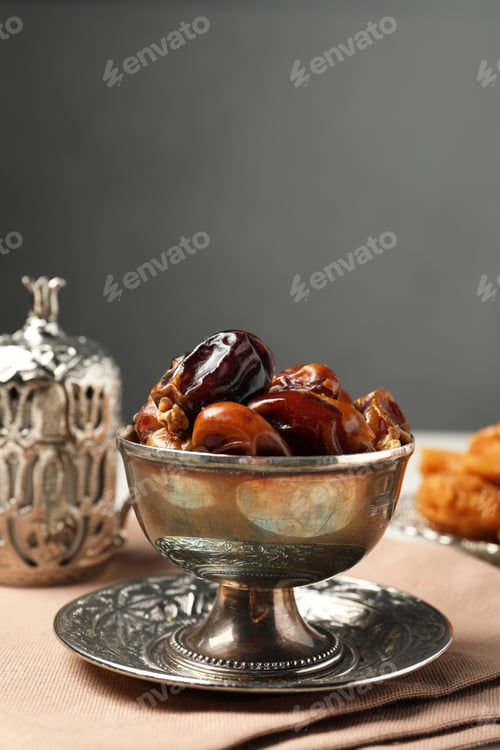Preview: Tea and date fruits served in vintage tea set on white table, space for text
