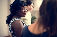 Preview: Three women in conversation indoors in the daytime