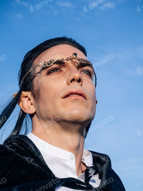Preview: Brown-haired man with elf ears, tiara on head and black cape, looks forward
