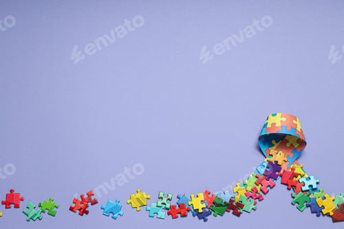 Preview: Ribbon with multi-colored puzzle pieces on a light background, place for text